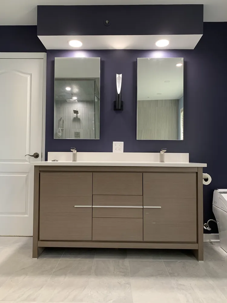 A stylish bathroom with blue walls and white countertops, emphasizing a bright and inviting atmosphere.
