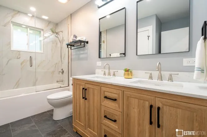 Elegant bathroom interior with a white tub and a wooden vanity, highlighting a blend of comfort and sophistication.
